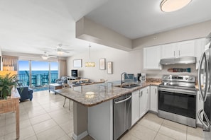 A modern kitchen with granite countertops, stainless steel appliances, and a view to the ocean. - Beach Front, "Resting Beach Face” 4006 Free Activities Included (Fort Walton Beach)