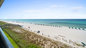 A beach with a wooden boardwalk, beach umbrellas, and a sandy shore. - Beach Front, "Resting Beach Face” 4006 Free Activities Included (Fort Walton Beach)
