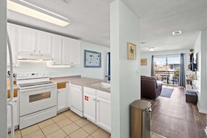 A modern kitchen with white cabinets, a built-in oven, and a dishwasher. - Walk to Beach! Free Activities! Coral Cove 301 (Fort Walton Beach)