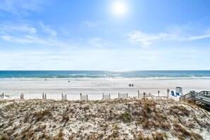 A beach with a sandy shore, a wooden fence, and a lifeguard tower. - Beachfront Bliss at Nautilus 1302 – Your Perfect Fort Walton Getaway! (Fort Walton Beach)