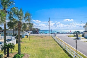 A coastal road with a white fence, palm trees, and a view of the ocean. - 🏖️Beach Views | Pool | Walk Across to Beach | Tradewinds #28- At the Beach!🏖️ (Miramar Beach)