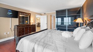 A hotel room with a large bed, a TV mounted on the wall, a dresser, and a mirror. - Beachfront~Beach Service~Stunning Views~Free Activities~Surf Dweller 210 (Fort Walton Beach)