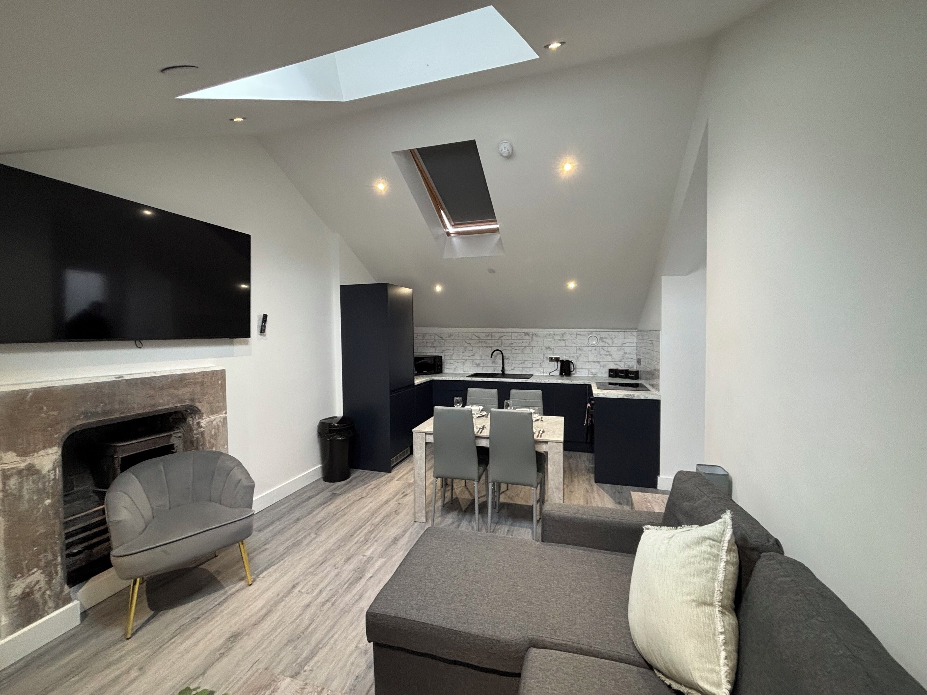A modern loft apartment with a dining area, kitchen, and living space.