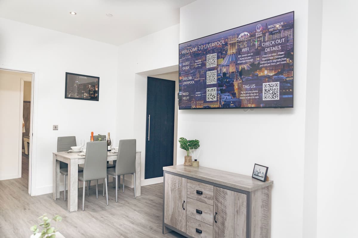 A modern dining area with a large cityscape artwork, a dark door, and a wooden cabinet with drawers.