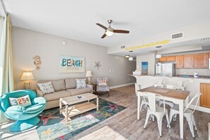 Ein wohnzimmer im Strandhausstil mit Sofa, Sessel und Esstisch.