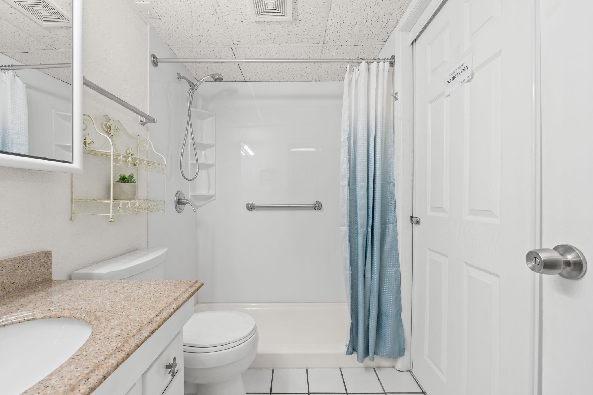 A modern bathroom with a white sink, toilet, and shower area.