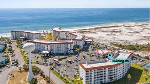 Ein Hotelkomplex an der Küste mit mehreren Gebäuden, einem Parkplatz und Blick auf den Strand.