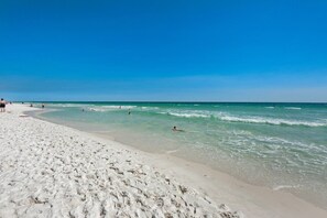 En strand med kristallklart blått vatten och en sandstrand.