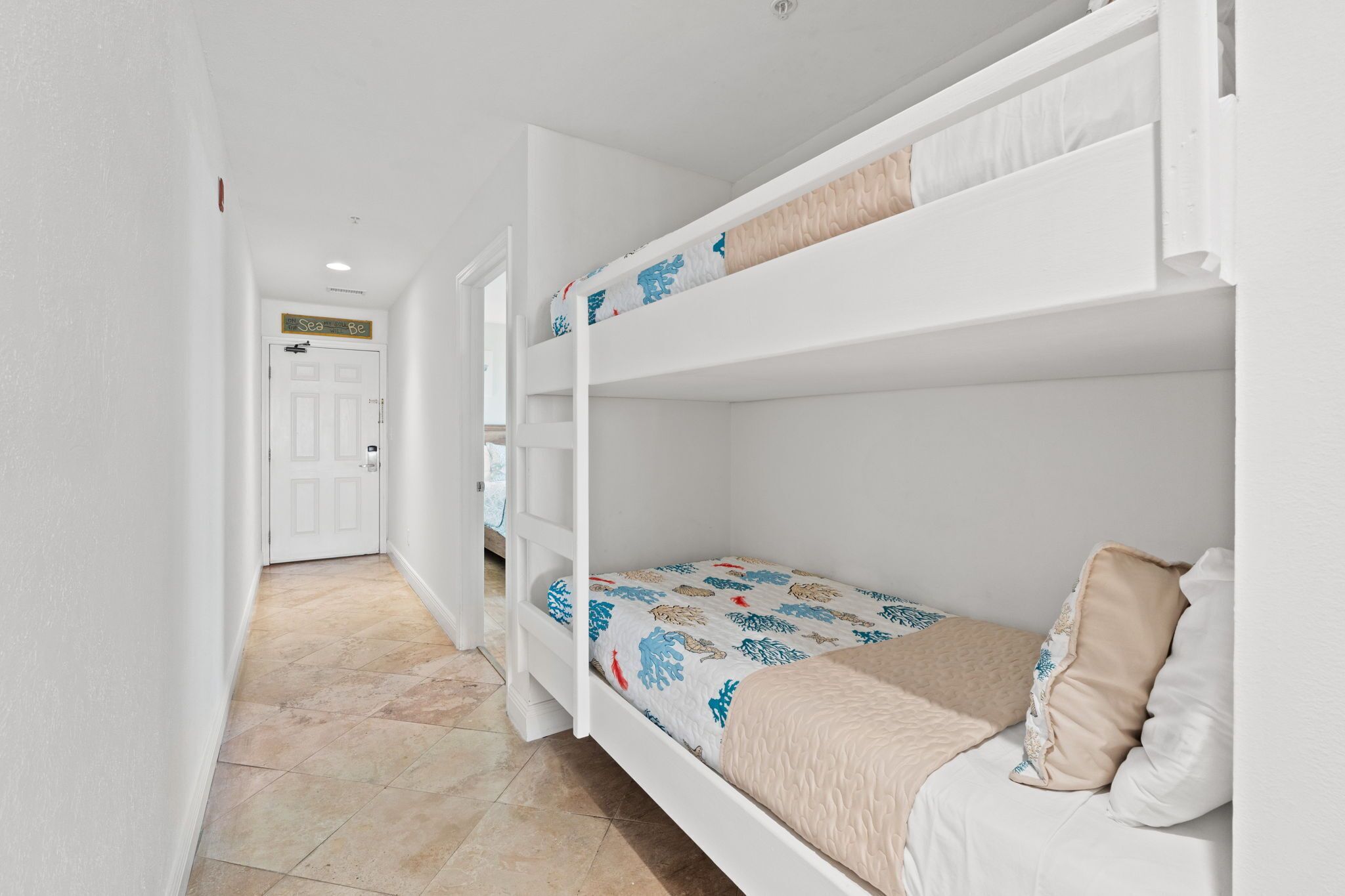 A bunk bed room with a door in the background.