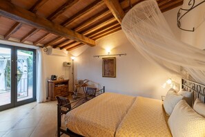 Une chambre à coucher avec un lit, un bureau, une chaise et une grande fenêtre.