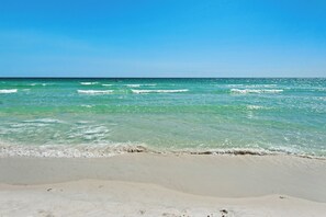 Ein Strand mit klarem türkisblauem Wasser und einem sandigen Ufer.