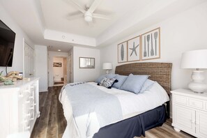 A bedroom with a large bed, a dresser, a ceiling fan, and wall art. - Ocean View 138th Street 3 BR, sleeps 12 with pool (Ocean City)