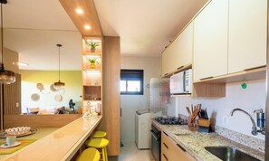 Eine moderne Küche mit Holzausstattung, einer eingebauten Mikrowelle und einem Gasherd.