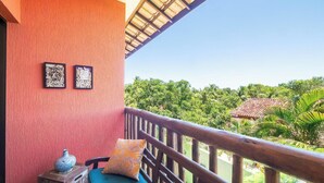A balcony with a wooden railing, a red textured wall, and framed pictures. - Apt in Condo w/ Pool 750 m Beach Rdw0103 (Camaçari)
