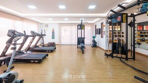 A gym with treadmills, a weight machine, and a wall clock. - Apt in Condo w/ Pool 750 m Beach Rdw0103 (Camaçari)