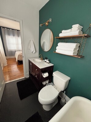 Un baño con inodoro, lavabo y toallero.