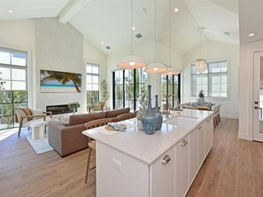 A spacious kitchen with a large island, a dining area with a sofa, and a living room with a fireplace. - Palmetto Paradise~Heated Pool/Spa, Steps to the Beach! (Anna Maria)