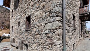 Um edifício de pedra com varandas de madeira e soalho de pedra.