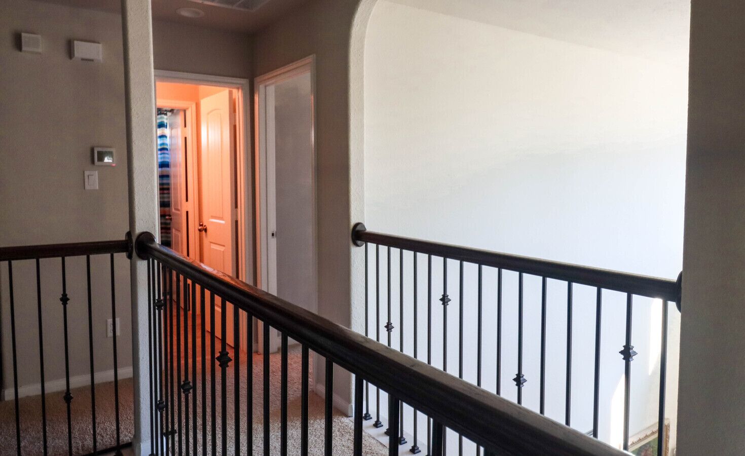 A staircase with a black metal railing leading to a landing.