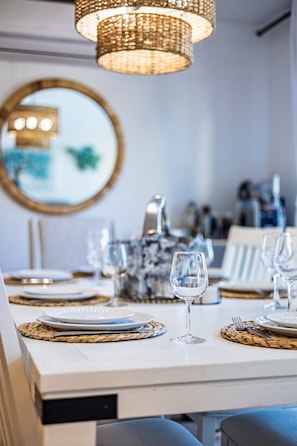 A dining table set with plates, glasses, and cutlery, a woven placemat, and a hanging light fixture. - Villa Crystal/5bedrooms/Lakefront Luxury/Hot tub (Beulah)