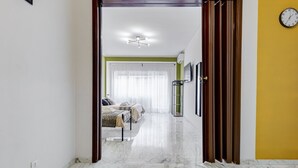 Ein Flur, der in ein Schlafzimmer mit einem Bett, einem Nachttisch und einer Lampe führt.