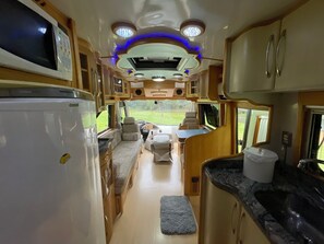 Ein kompaktes Wohnmobil-Interieur mit Küchenzeile, Essbereich und Bad.