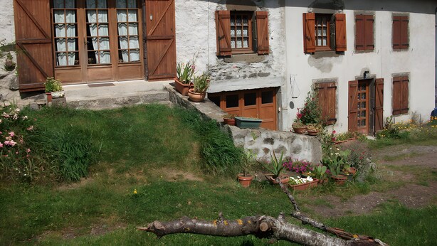 Un bâtiment de style rustique, doté d’un toit en pente, de volets en bois et de fondations en pierre.