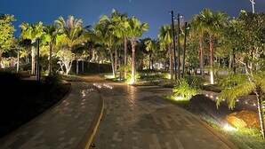 A paved pathway lined with palm trees and illuminated by street lamps. - MK Hotel Phu Quoc (Phu Quoc)