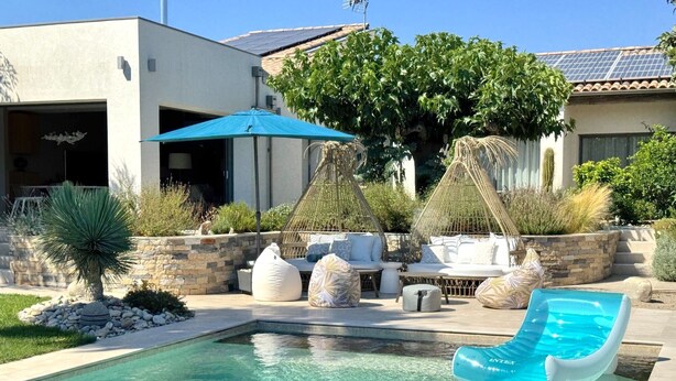 A swimming pool with a slide, outdoor seating, and a stone wall. - Villa Balāo - Guesthouse Men Only - LGBT (Balaruc-les-Bains)