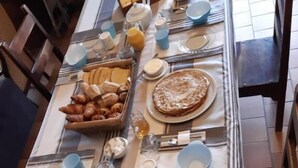 A dining table set with breakfast items including pastries, a fruit bowl, and a plate of pancakes. - Oh Fleurs des Champs (Chaumont-sur-Tharonne)