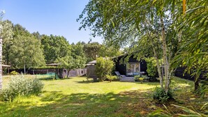 A garden with a wooden cabin, a small pond, and a variety of trees. - La Forestière 3 Guest Room with Private Entrance in a Green Setting (Lacanau)