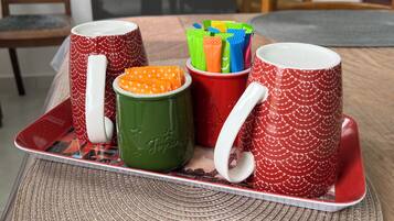 Un plateau avec quatre tasses et un ensemble de pailles colorées, le tout posé sur un set de table en fibres tressées.