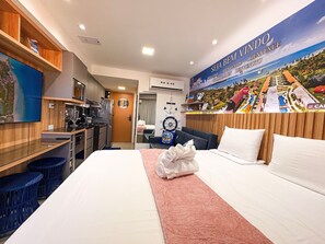 A hotel room with a bed, a desk, a kitchenette, and a bathroom. - Flats no Carneiros Atlantico - Proximo da Igrejinha (Tamandaré)