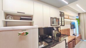 A modern kitchen with a refrigerator, microwave, and sink. - Flats no Carneiros Atlantico - Proximo da Igrejinha (Tamandaré)