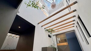 Een modern interieur met een houten bankje, een kleine plantenbak en een dakraam.