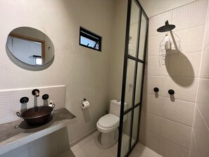 Een douche, handdoeken, zeep, toiletpapier