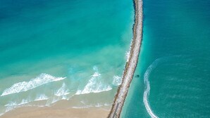 An aerial view of a beach with a long stretch of rocky shoreline and clear turquoise waters. - Amarco - Waterfront Sunsets in Iluka (Iluka)