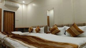 A hotel room with a large bed, a wooden wardrobe, a mirror, and an air conditioning unit. - Shree ShyamRaj Hotel (Ujjain)