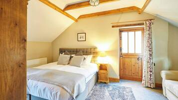 A bedroom with a bed, a nightstand, a wooden door, and a window.