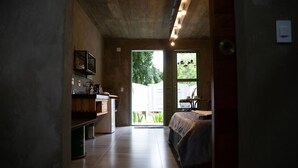 Un interno moderno con angolo cottura, un letto e un'ampia finestra che offre vista sull'esterno.