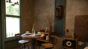 Un'accogliente sala da pranzo con un tavolo in legno, sedie in metallo e una vecchia orologio.