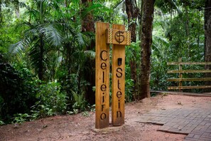 A wooden signpost with the names 'Celoiro' and 'Stein' carved into it, set against a lush green forest background. - Casa Norma Wi-fi e Lago em Meio Natureza (Domingos Martins)