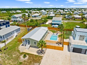 A residential area with houses, a swimming pool, and a fenced yard.