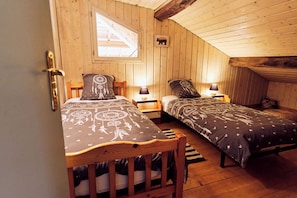 A cozy room with two beds, wooden walls, a window, and a bear picture on the wall. - Large gîte for 6 in quiet countryside, 3 bedrooms, 3 bathrooms, swimming pool (Saint-Vérand)