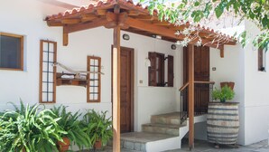 Un bâtiment doté d’une pergola en bois, d’un escalier et de plantes en pot.