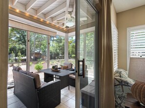 A covered patio area with wicker furniture, a table, and a ceiling fan. - Ground Floor, 2 Community Pools, Pro Tennis, Deeded Beach Access (Miramar Beach)