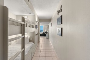 Passadís d'hotel amb llits superposats, una cuineta i vista al mar.
