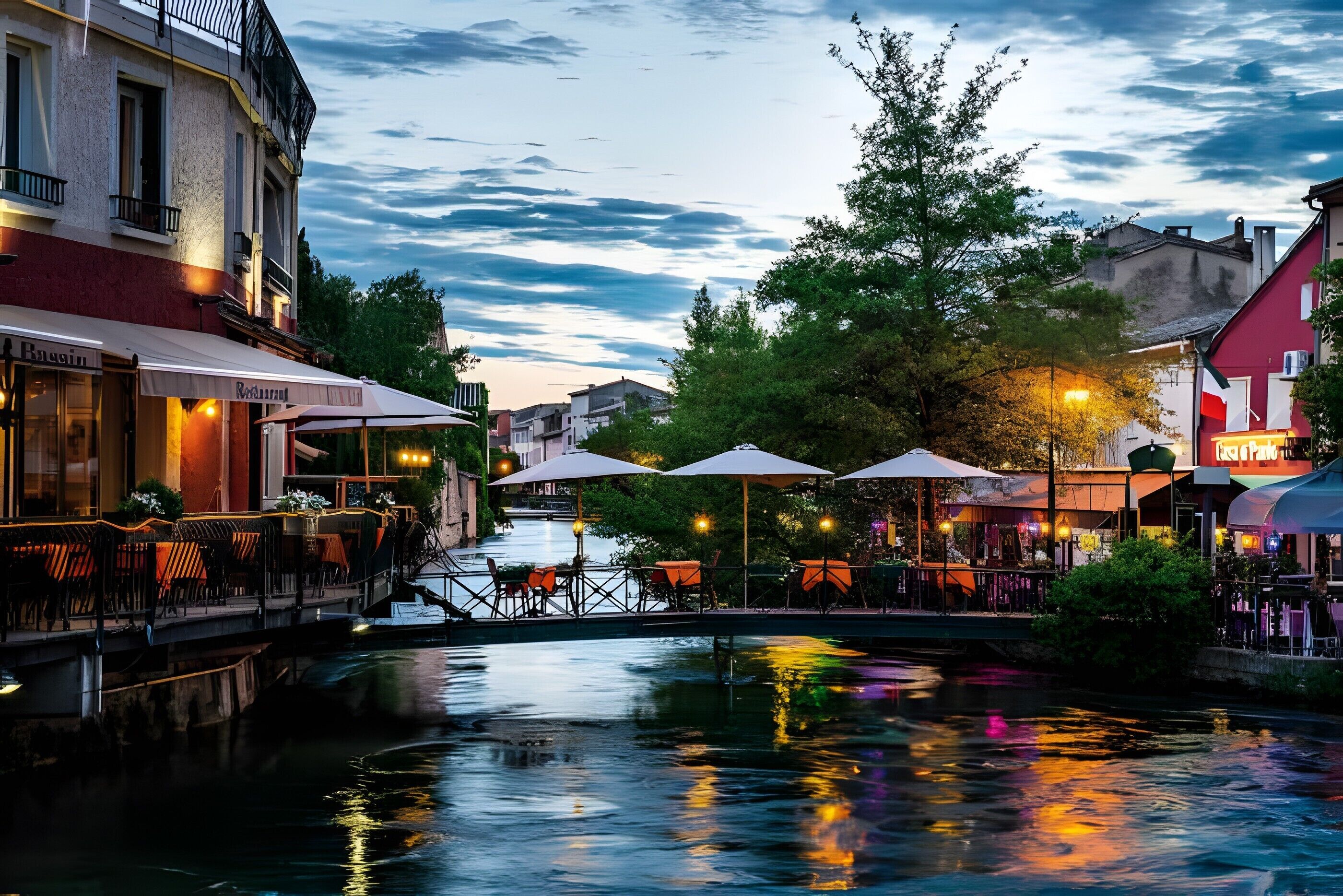 Ein Restaurant am Flussufer mit Terrassenplätzen, einer Brücke und Gebäuden entlang des Wassers.