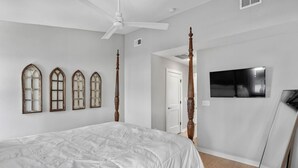 A bedroom with a bed, a ceiling fan, a TV, and a mirror. - Lucky #7 Hip East Nash Townhome + Rooftop Deck (Nashville)