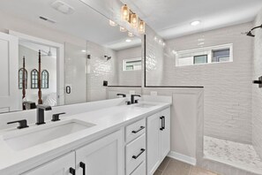 A modern bathroom with a large vanity, a walk-in shower, and a large mirror. - Lucky #7 Hip East Nash Townhome + Rooftop Deck (Nashville)
